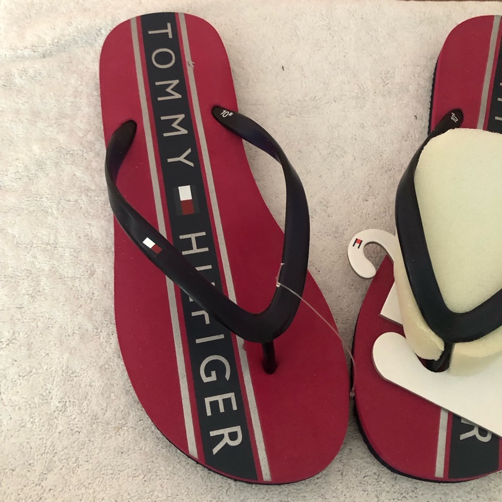 Tommy Hilfiger red flip flops with dark navy straps, sole.